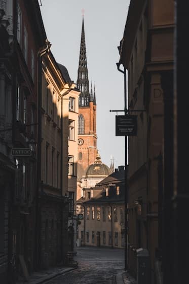 Kapea katu vanhassakaupungissa, taustalla korkea kirkontorni ja vanhoja rakennuksia.
