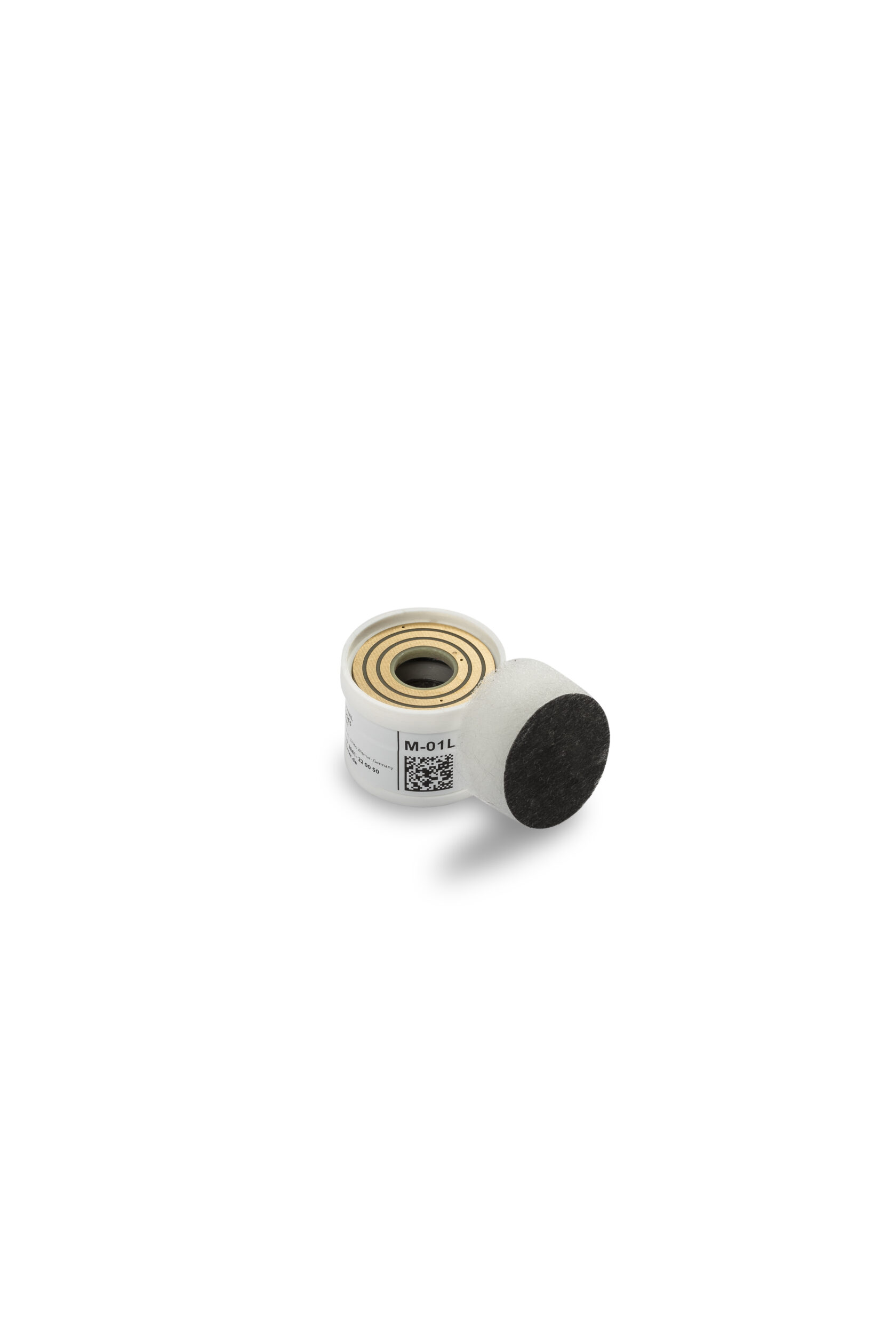 Liten vit cylinderformad sensor med en guldtopp och QR-kod, bredvid ett svart cirkulärt skumfilter.