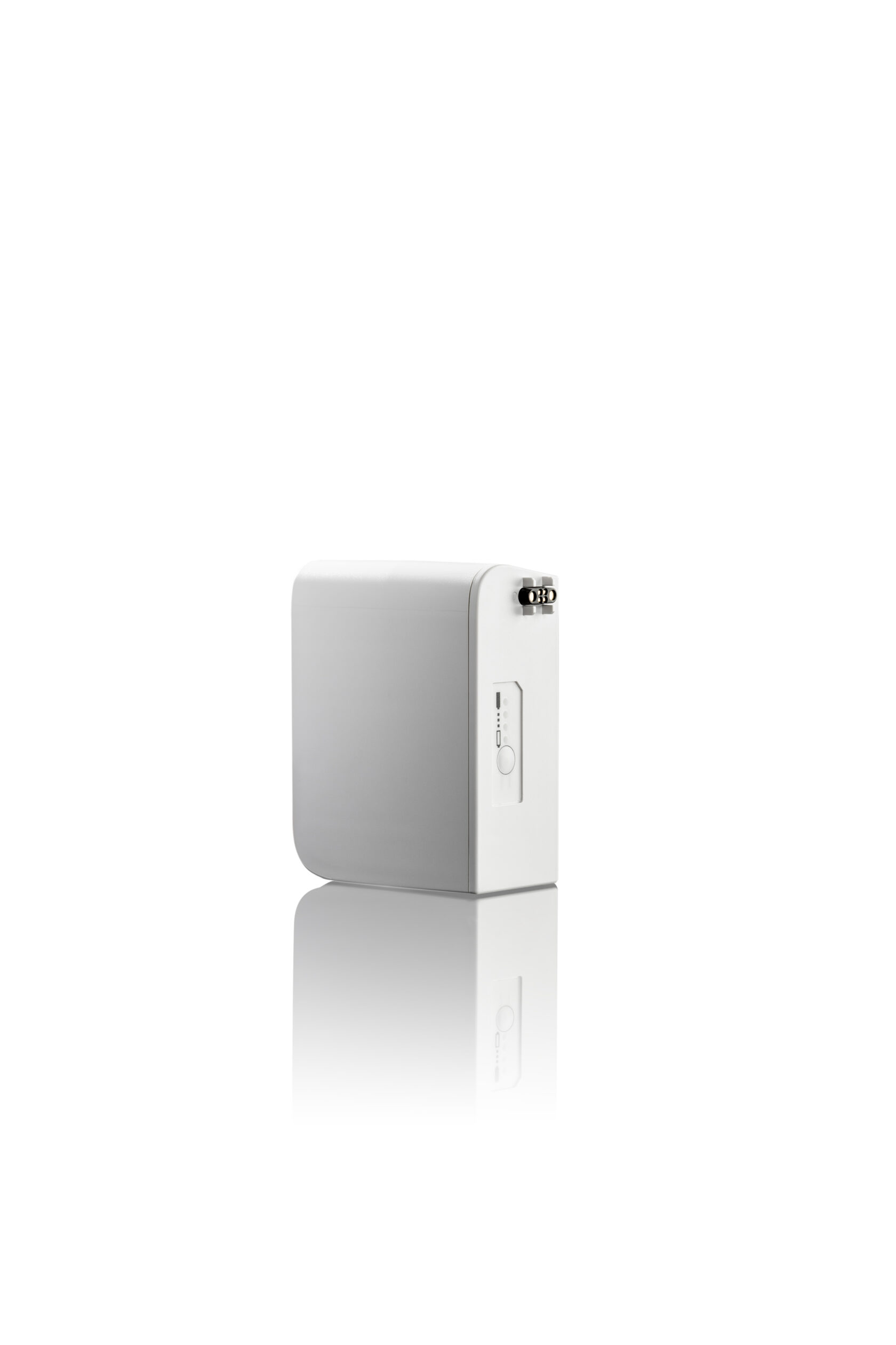 Vitt rektangulärt elektroniskt apparat med en sidoknapp, reflekterad på en blank yta, isolerad på vit bakgrund.