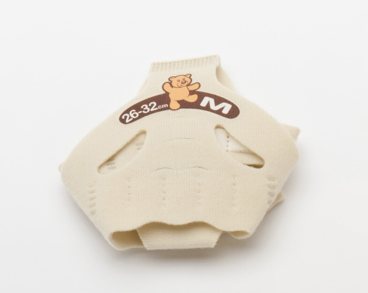 Beige tygartikel märkt "26-32 cm M" med en söt björnseriefigur, sedd på en vit bakgrund.