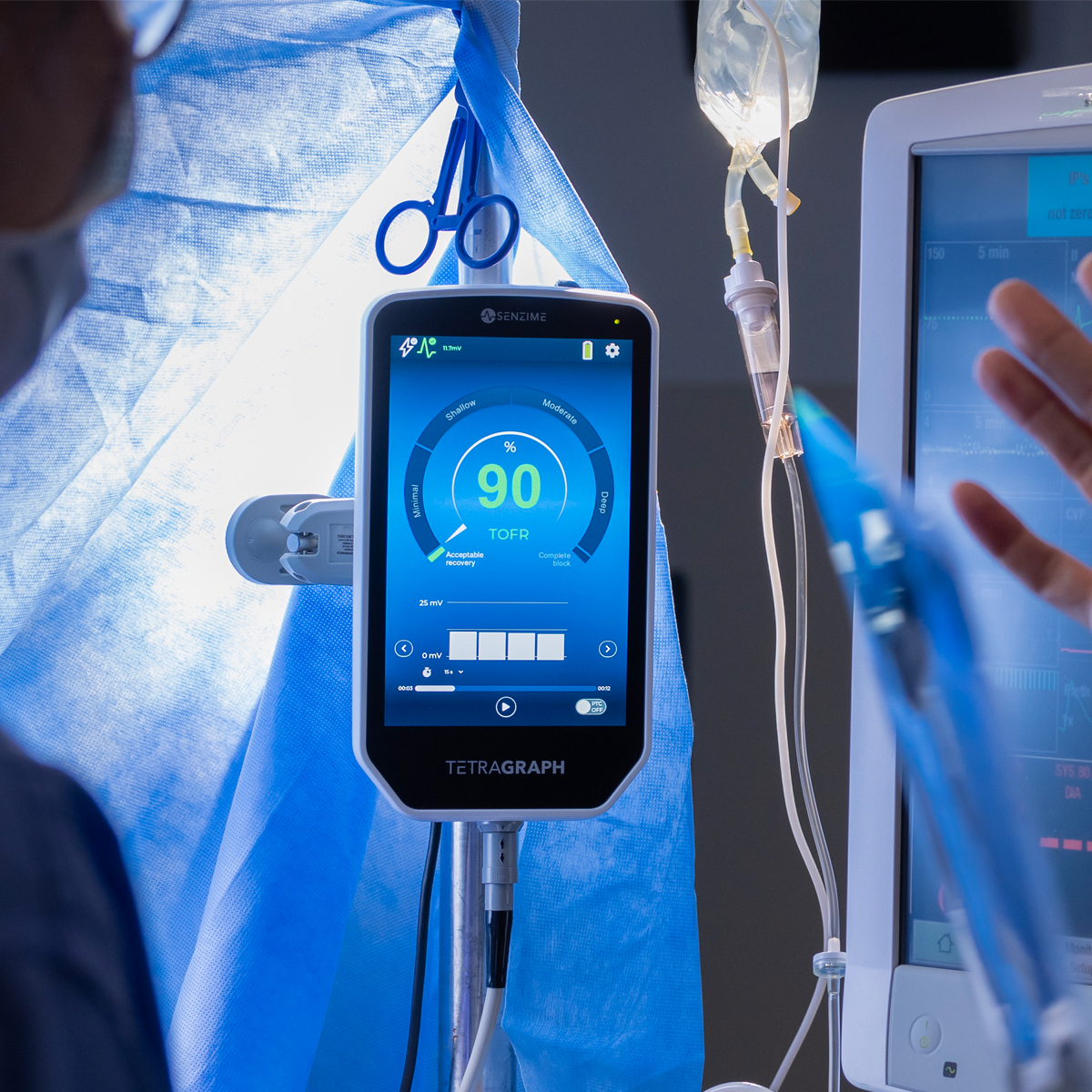 Medicinsk monitor som visar ett TOFR-värde på 90 % i en sjukhus- eller operationsmiljö med blå drapering och utrustning.