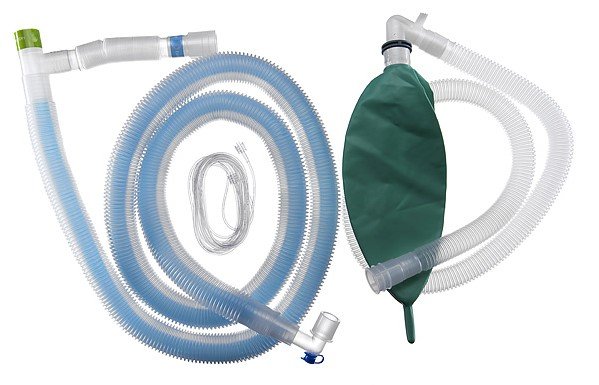 Lääketieteellinen hengityspiirisetti poimutetuilla putkilla ja vihreällä säiliökassilla valkoisella taustalla.