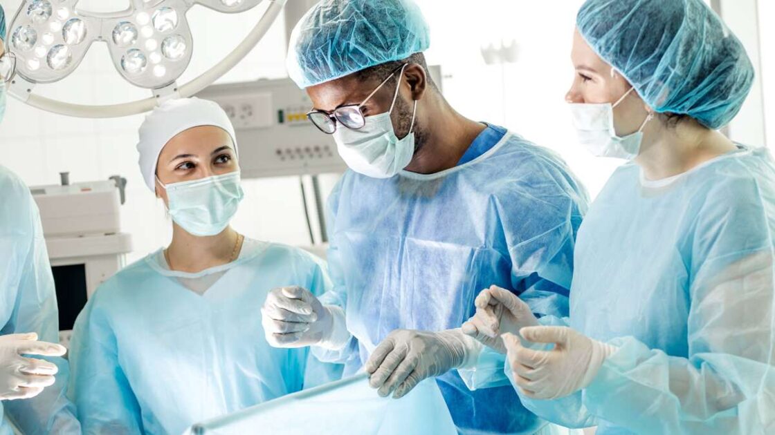 Anestesiahoitajat ja lääkäri leikkaussalissa anestesiassa oleva potilas