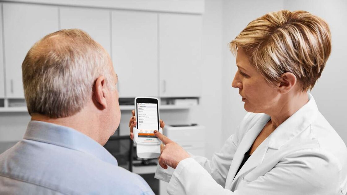 Vanhempi mies vastaanottamassa analyysi- ja palautelomaketta kliinikolta