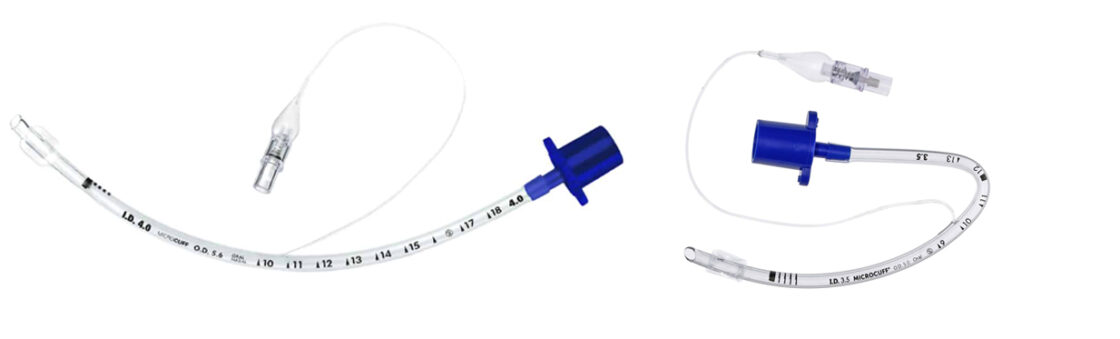 Kaksi kirkasta lääketieteellistä endotraheaaliputkea sinisillä liittimillä, kaarevat ja merkityt mittausviivoilla.